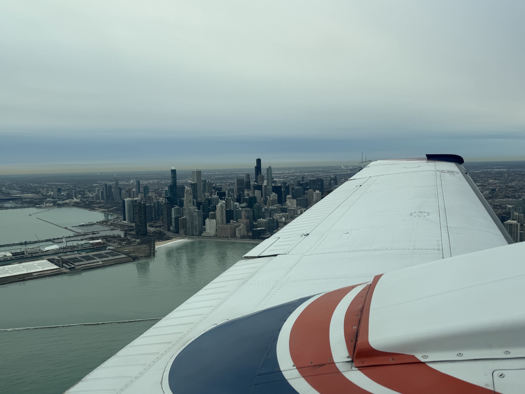 Beechcraft Baron 58 wing over the Chicago skyline and Lake Michigan